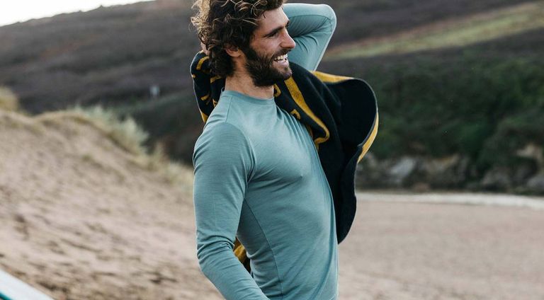 best base layer: Man wearing Finisterre Eddy base layer at the seaside