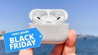 The AirPods Pro 2 being held up with the ocean in the background