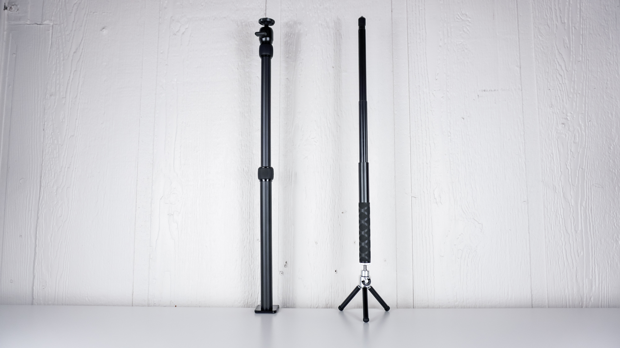 The SmallRig Camera Desk Mount mounted to the back of a table next to a DIY solution made from a selfie stick and mini tripod