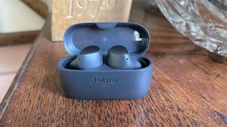 Jabra Elite 3 earbuds with case on a wooden table