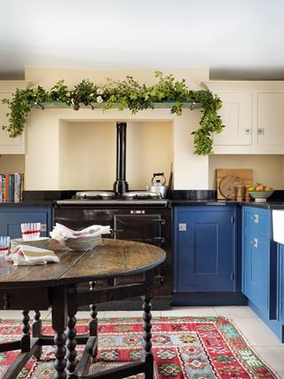 Blue kitchen with range cooker and red kilim rug
