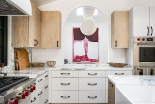 white kitchen with an arch through to the dining room