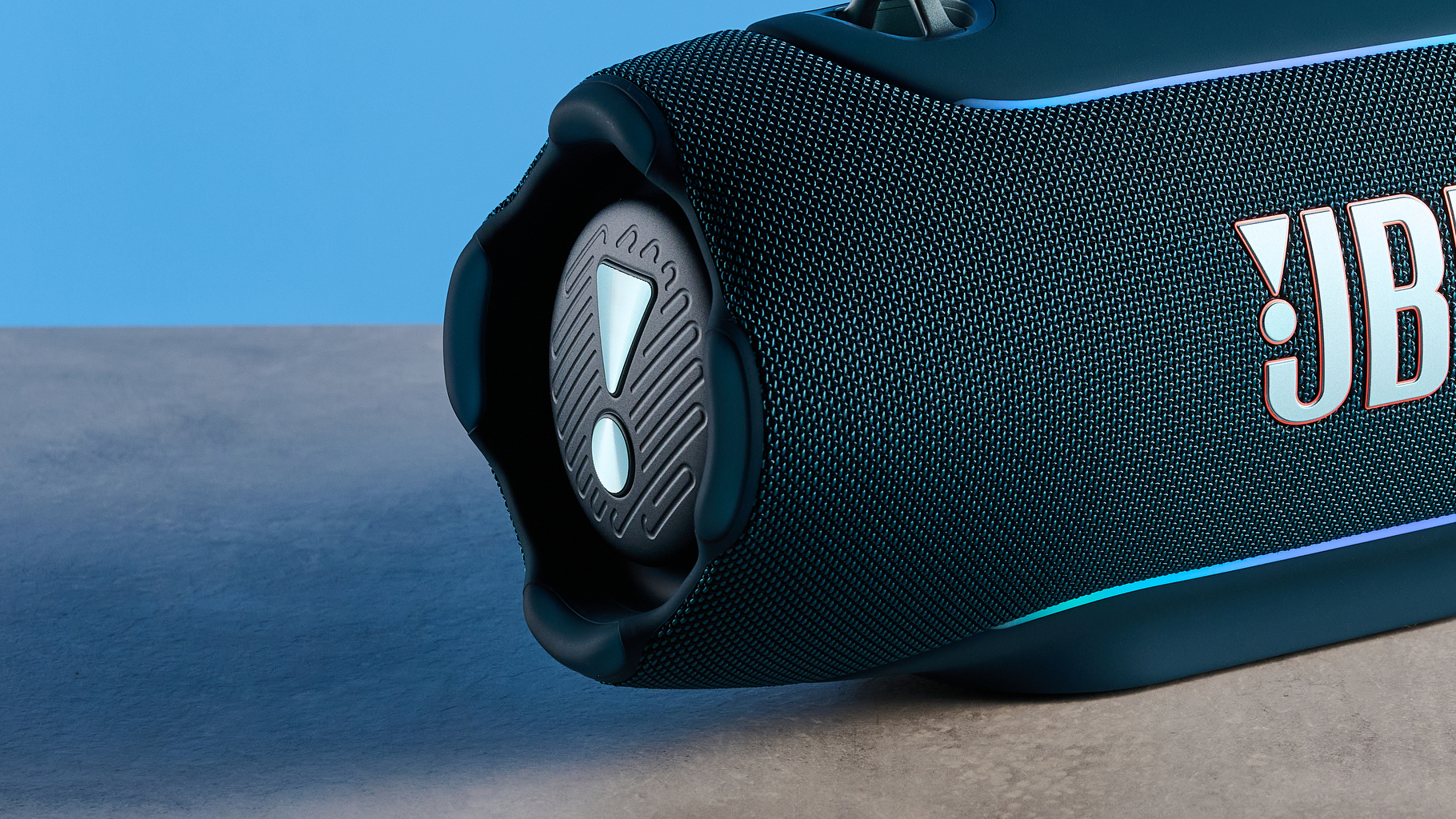 the JBL Xtreme 5 bluetooth speaker in blue shown with the rugged carry strap and buttons