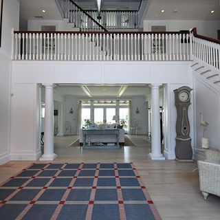 living area with white wall and wooden floor and stair case