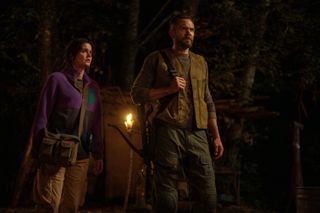 ashley sutton as frog researcher hannah and joel mchale as kodi standing in the woods in season 3 episode 7 of yellowjackets