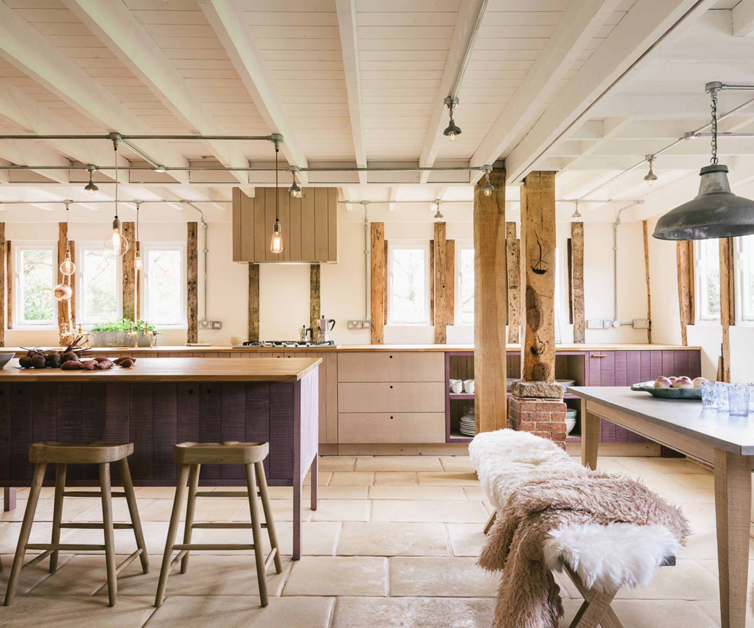 purple freestanding wooden kitchen within barn conversion with flagstone flooring