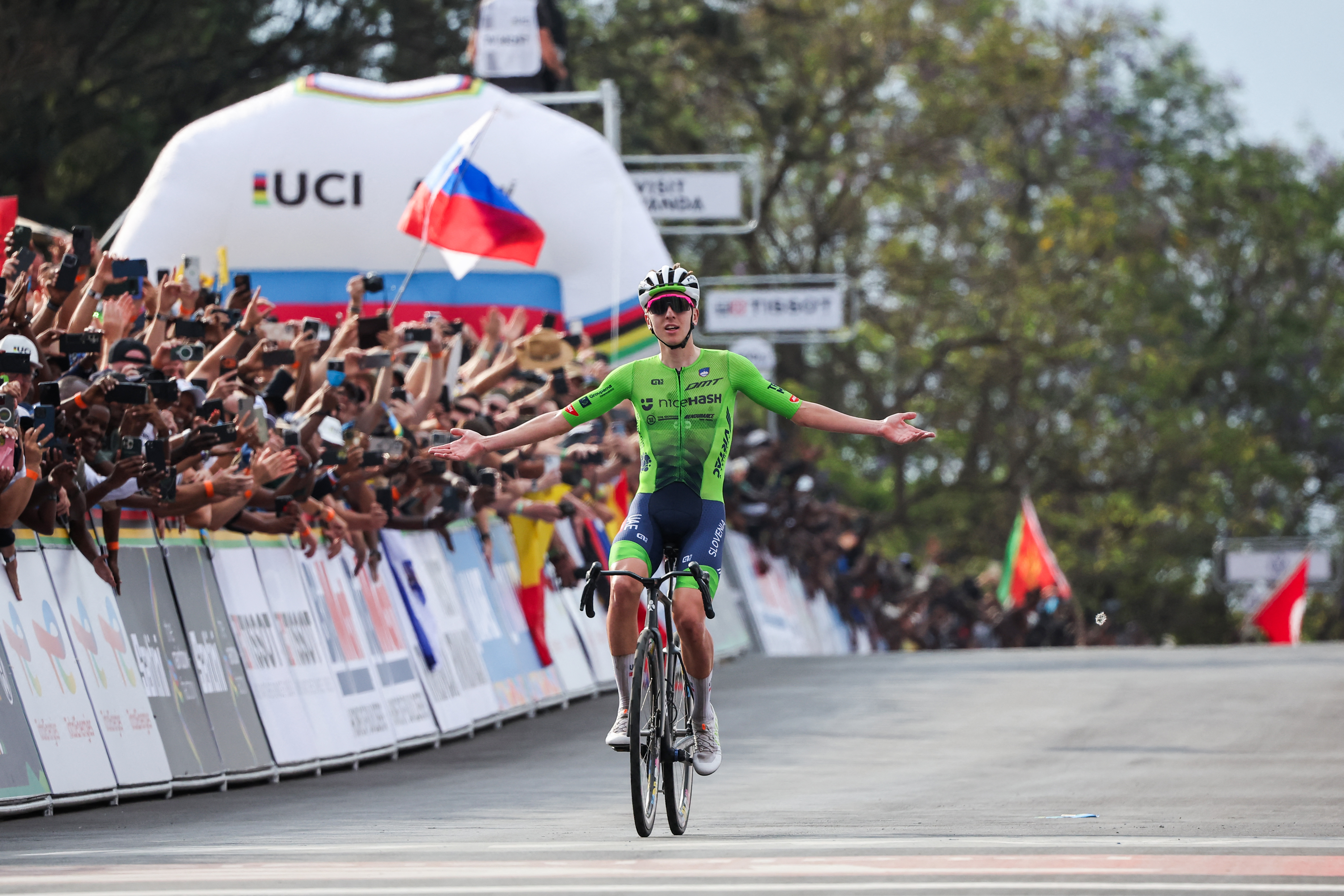 TOPSHOT - Slovenian rider Tadej Pogacar celebrates as he crosses the finish line to win the men's Elite road race cycling event during the UCI 2025 Road World Championships, in Kigali, on September 28, 2025. (Photo by Anne-Christine POUJOULAT / AFP via Getty Images)