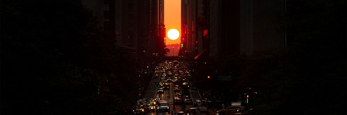 sun setting between buildings in manhattan