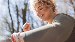 Happy woman checking sports watch