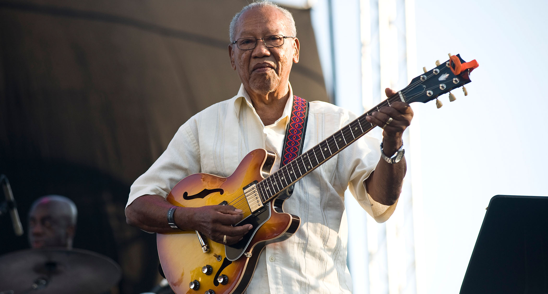Ernest Ranglin plays his Gibson archtop onstage in 2013 during a sunny afternoon festival slot in Barcelona.