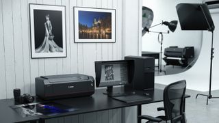 Canon ImagePrograf Pro-1100 on a desk, in a professional studio, next to a computer monitor and printed photos