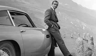 Sean Connery's Bond surveys the swiss alps leaning on a DB5