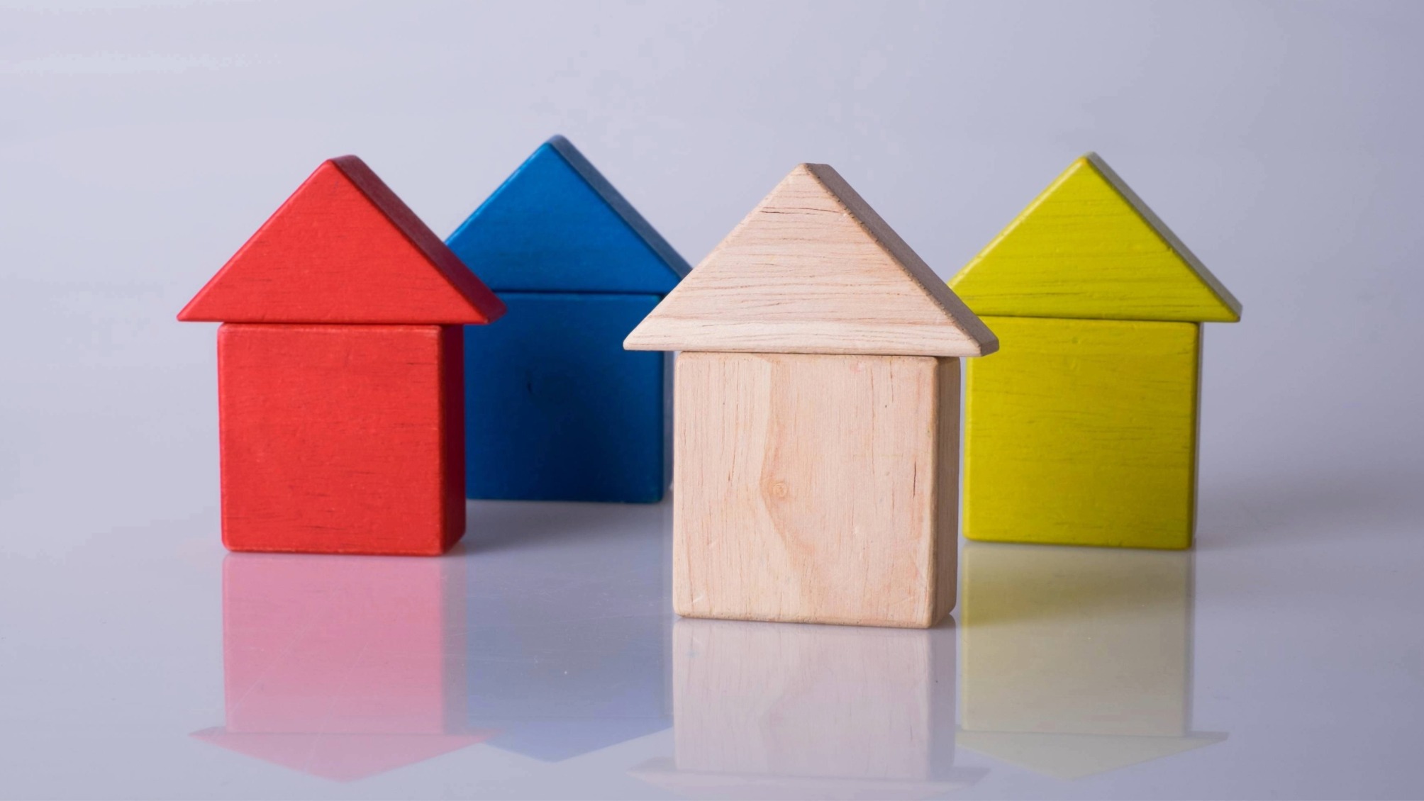 Close up of coloured wooden building blocks in the shape of houses