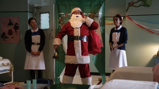 Cliff Parisi as Fred Buckle dressed as Santa stands in a hospital ward next to two nurses in the Call the Midwife Christmas Special 2024.