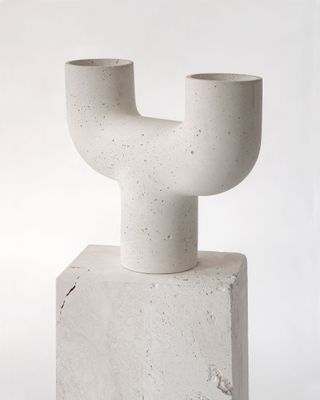 View of the ‘Temu’ concrete lamp by Studiopepe on a plinth pictured against a light coloured background