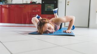 Woman on the floor smiling after doing the press-up exercise