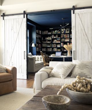 Men's home office with blue walls and white barn sliding doors