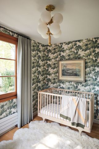 wooden cot with tree wallpaper and white sheepskin rug and multi globe ceiling light