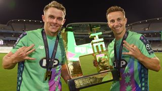 Sam Curran and Tom Curran of Oval Invincibles hold the trophy after The Hundred Final match between Oval Invincibles Men and Trent Rockets Men at Lord's Cricket Ground on August 31, 2025 in London, England.