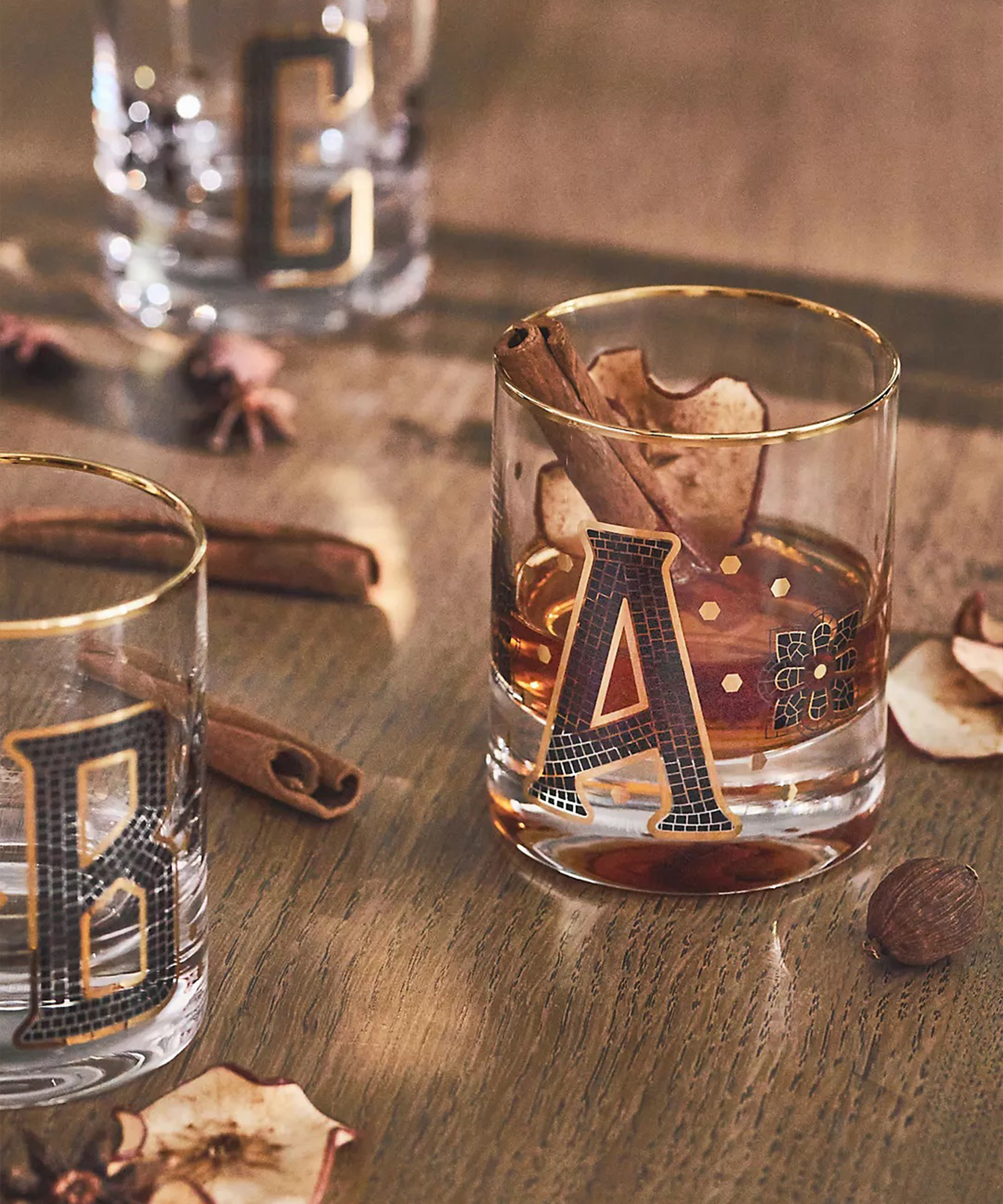 Mug bermonogram dengan huruf-huruf yang dieja dari ubin hitam dan emas