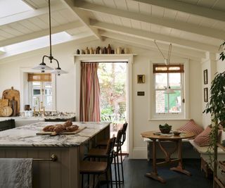 White country house kitchen with sloping ceiling and striped curtain on the door