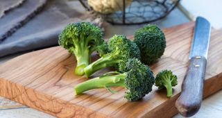 Florets of broccoli on wooden chopping board