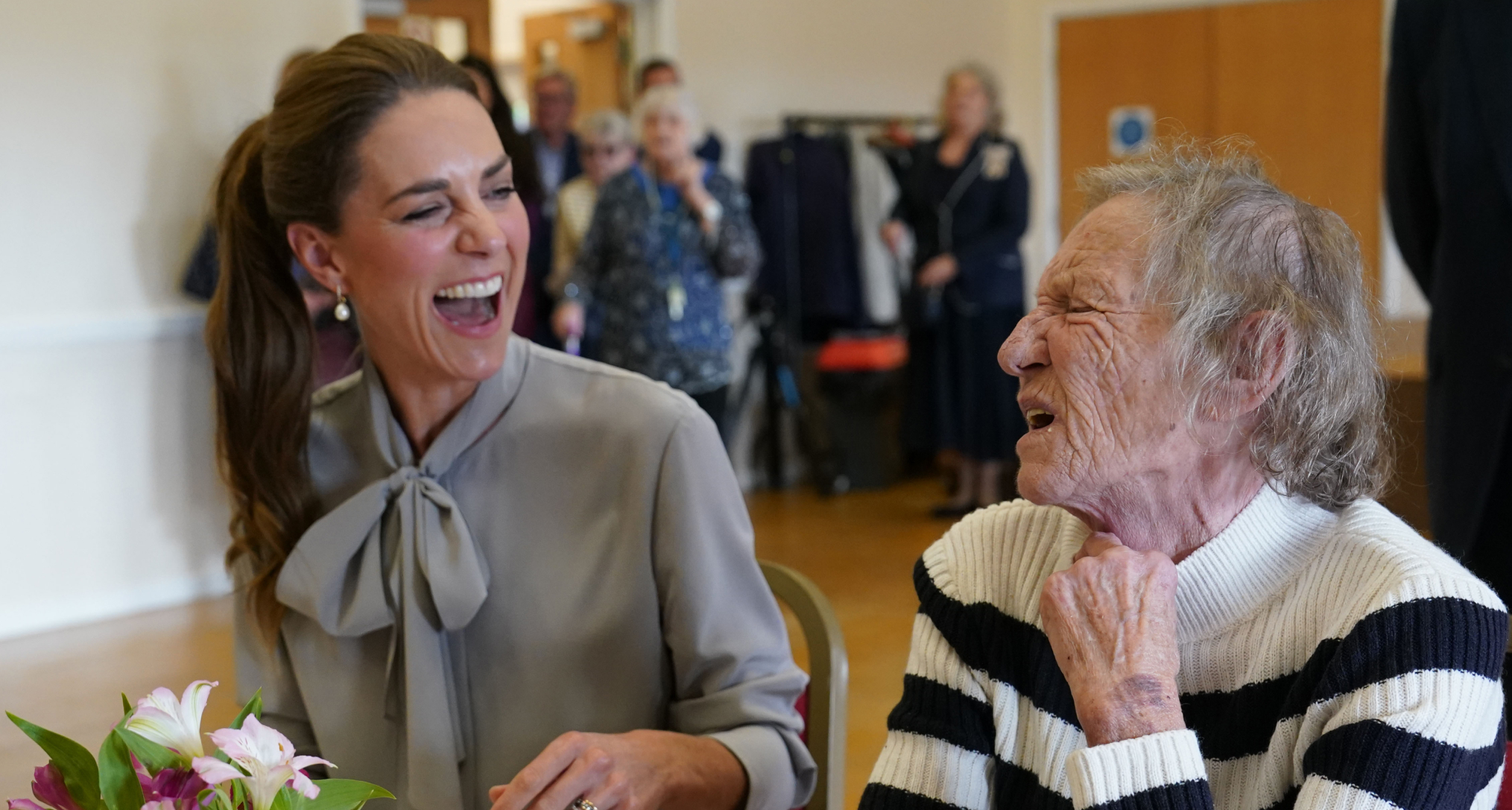 Princess Kate laughing with a woman at a table