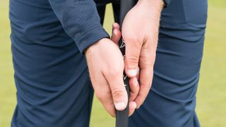 Tour coach Liam James gripping a putter at the London Club