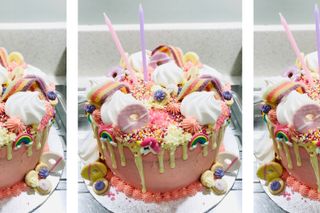 Close up of pink cake topped with mini meringues, sprinkles, chewy sweets, rainbow laces and more