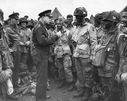 Dwight D. Eisenhower Talking to Paratroopers (Original Caption) 6/9/1944-England- General Dwight D. Eisenhower, Supreme Commander of the Allied Expeditionary Forces, gives the order of the day "Full Victory--Nothing Else" to paratroopers somewhere in England. These first assault troops, faces blackened, boarded their planes immediately after for the flight across the Channel.