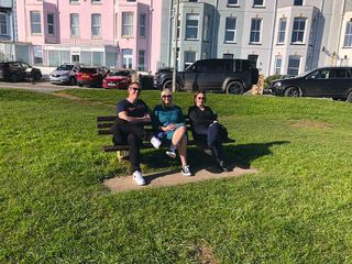 Natasha and her siblings as adults on a park bench