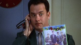 Tom Hanks holds up the record single with an urgent look in That Thing You Do!