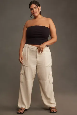 model wears white linen cargo pants with black strapless tube top