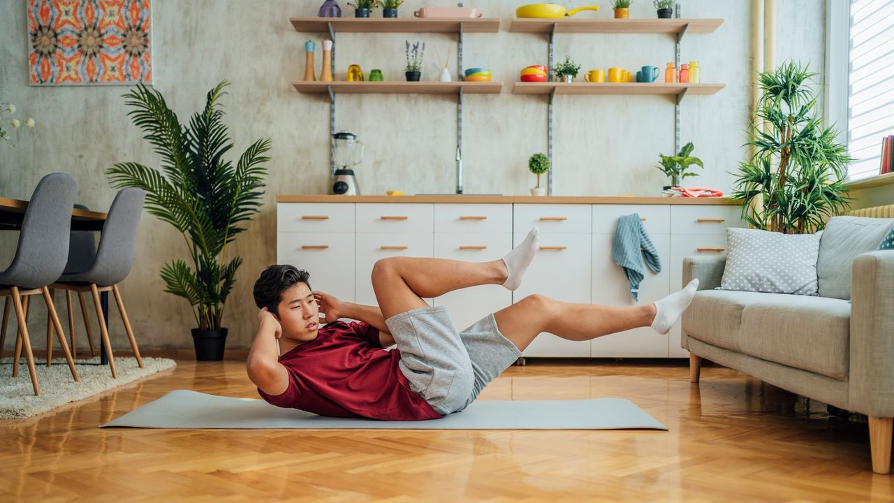 A man performing a bicycle crunch as part of a home ab workout