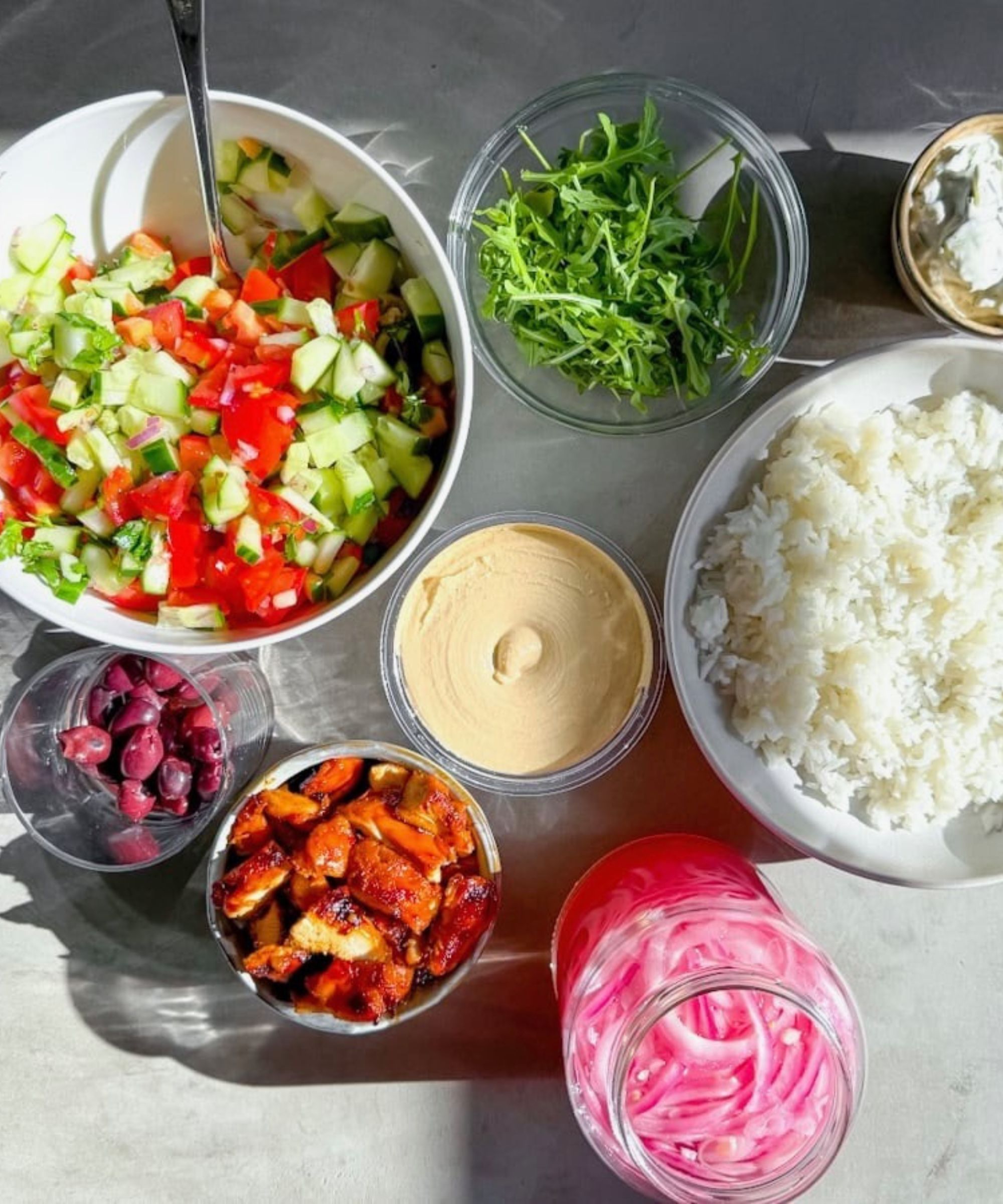 bowls of vegetables, salad, rice and sauces