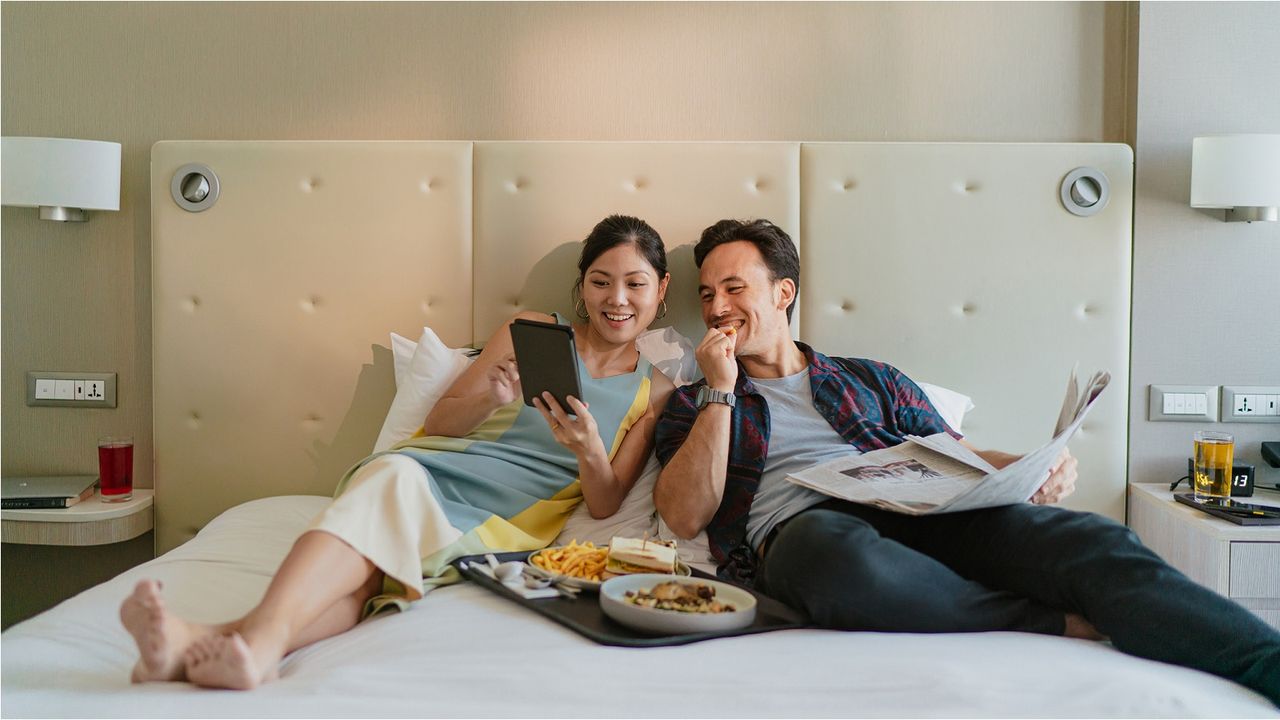 A couple relax on a hotel bed.