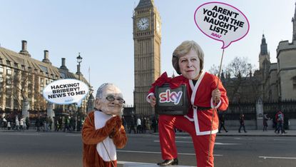 rotesters dressed as Rupert Murdoch oppose the Sky takeover outside Parliament