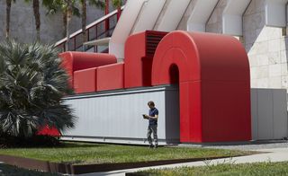 Artist outside building with bold red design