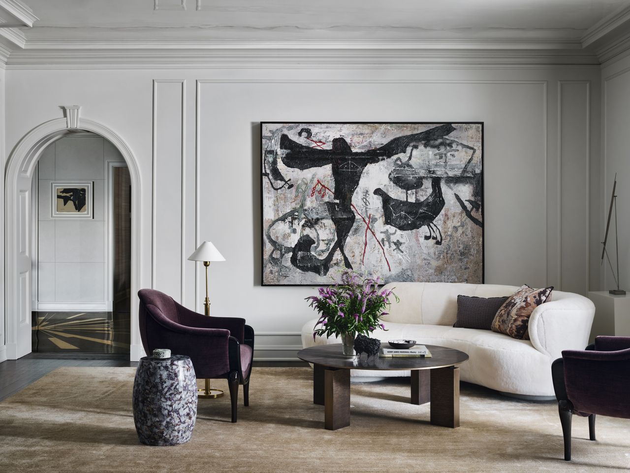 large white living room with curved white sofa and round coffee table