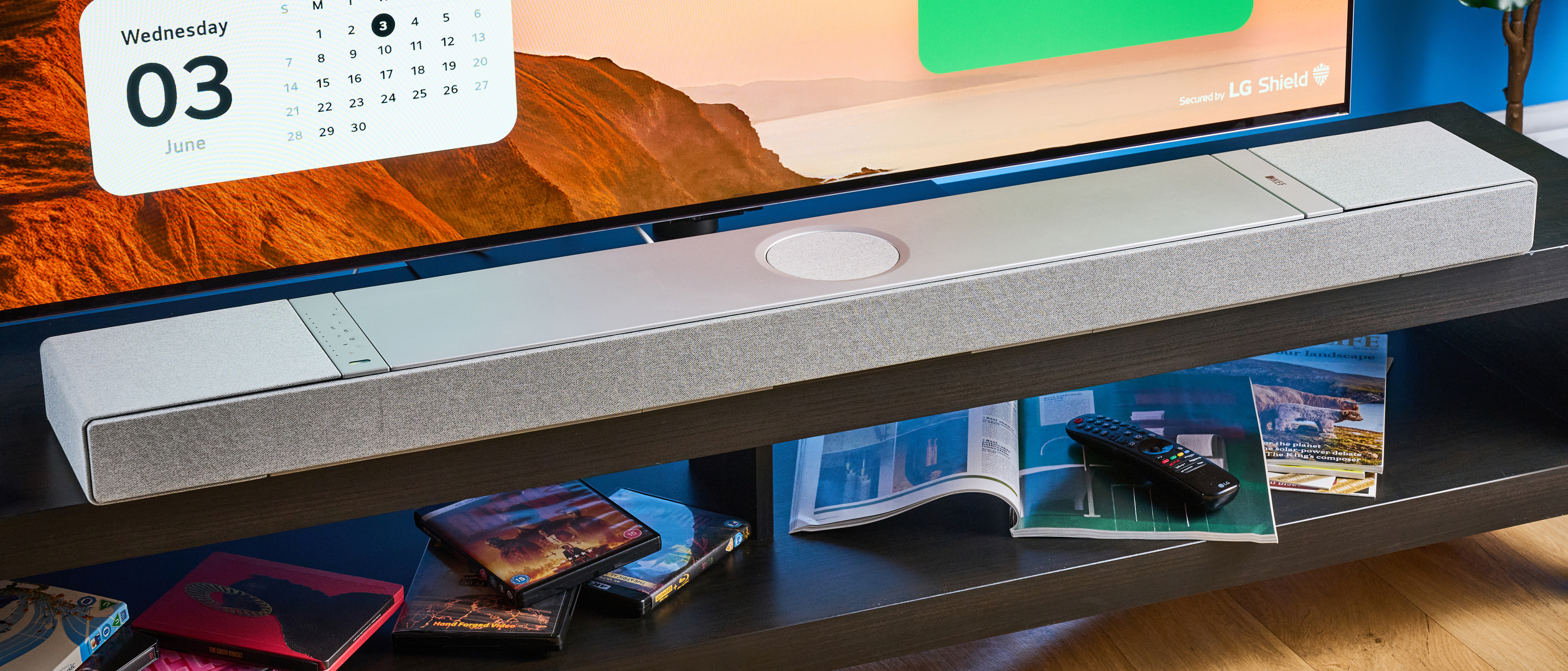 the KEF XIO soundbar in gray photographed with a TV and the Tom's Guide blue background