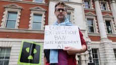 A man in London holds a protest sign against superintelligent AI