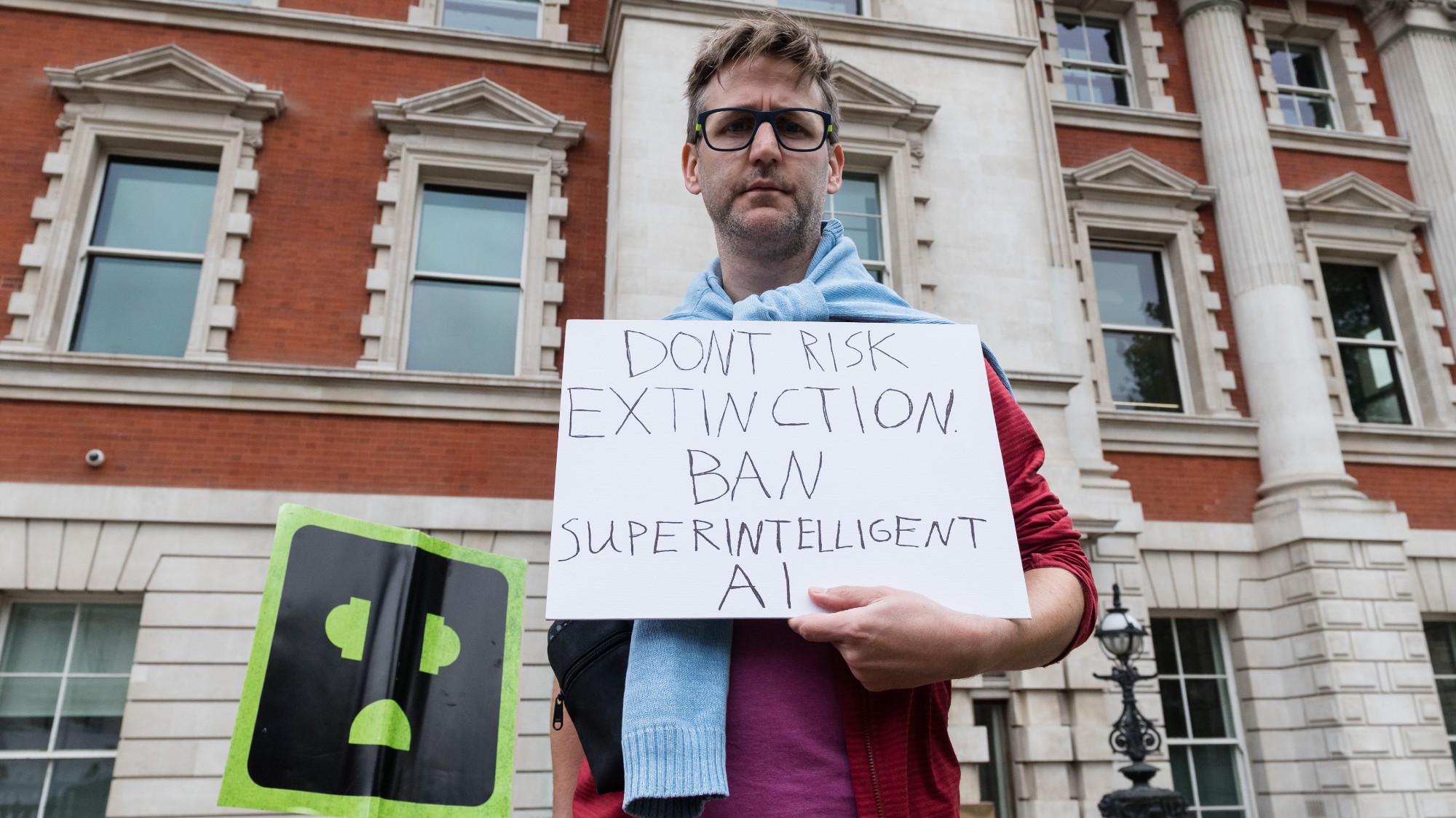 A man in London holds a protest sign against superintelligent AI