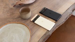 A Pixel 6 and a Pixel 6 Pro sat on a wooden table