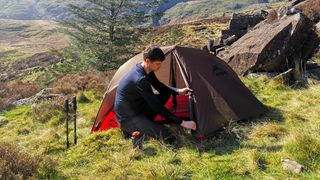 Man setting up tent for wild camping