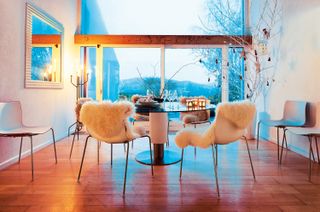 Scandinavian style dining area with a large picture window at dusk