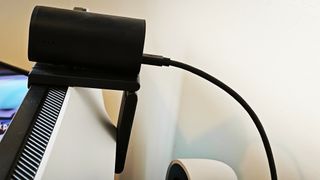 A black HP 965 4K webcam perched on a monitor