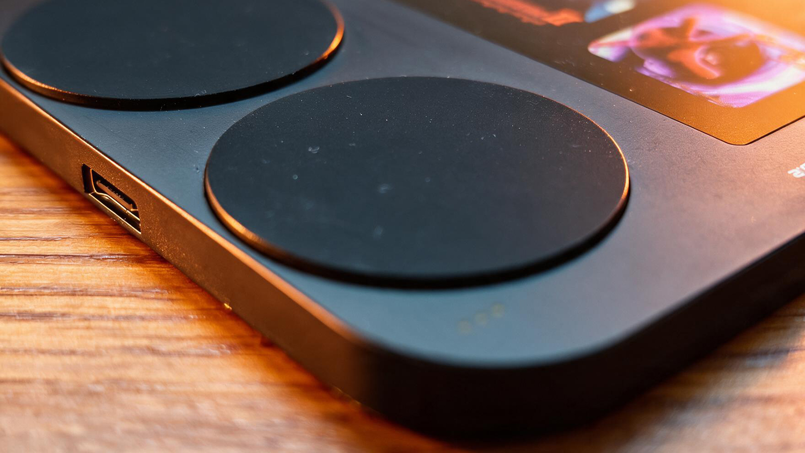 A small black gaming handheld in a wooden table