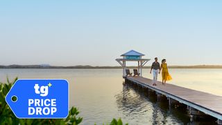 A couple walks on a dock at the Mahogany Bay Hilton