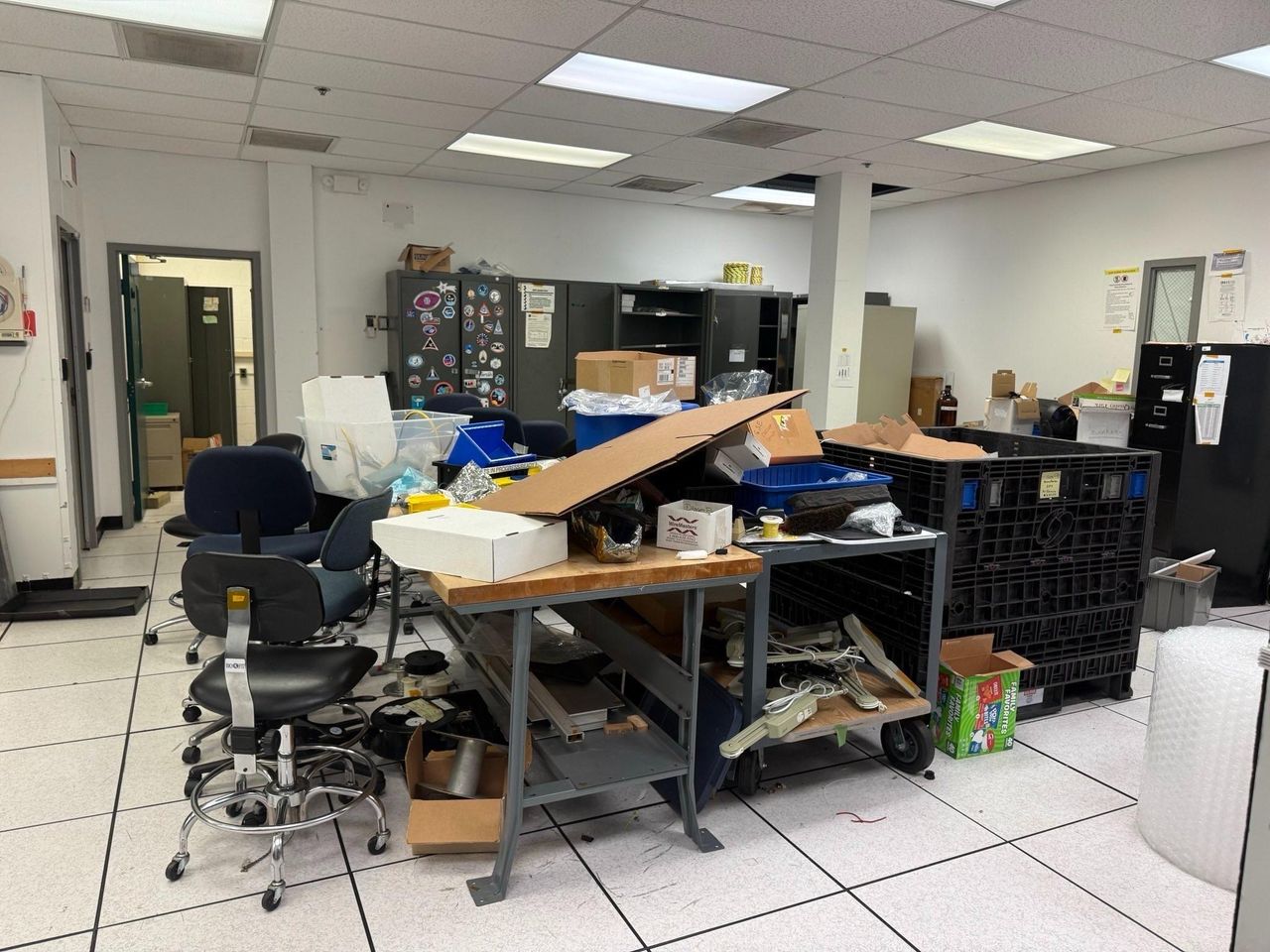 Various office spaces including desks, shelves and warehouses full of items stacked ready to be removed.