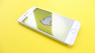 Snapchat Logo on white iphone on yellow background